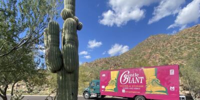 The purple Gentle Giant moving truck is parked at the bottom of Camelback Mountain in Phoenix, Arizona.